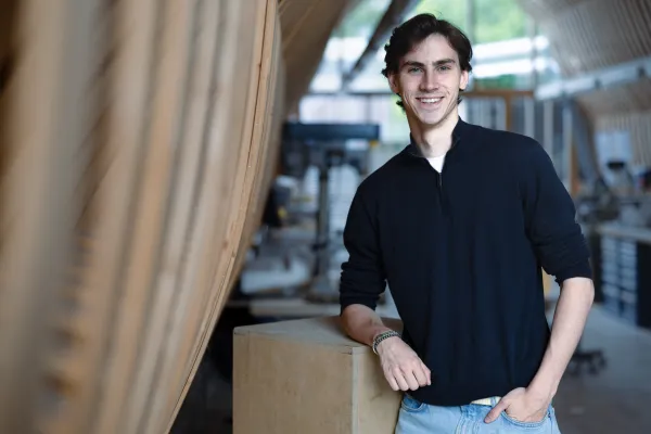 Studierender des Master Architektur der Universität Liechtenstein mit schwarzem Pullover steht in der Modellwerkstatt