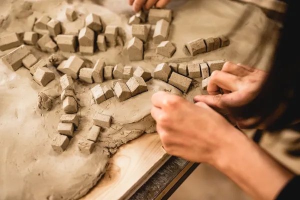 Zwei Hände, die ein Modell aus Lehm formen