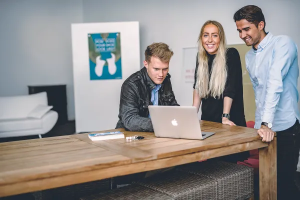 Masterstudierende im Studiengang Entrepreneurship und Management der Universität Liechtenstein arbeiten gemeinsam an einem Projekt am Laptop in moderner Lernumgebung.