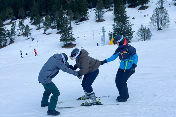 Studierende beim Skifahren mit Skilehrer