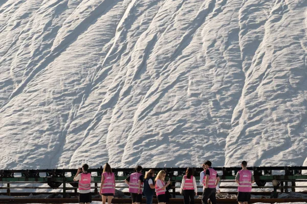 Gruppe Menschen vor einem grossen Salzberg