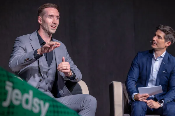 Referenten diskutieren auf Podium bei Wirtschaftskonferenz vor Publikum