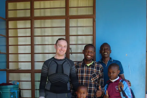 Gruppe von Personen steht vor einem blauen Gebäude.